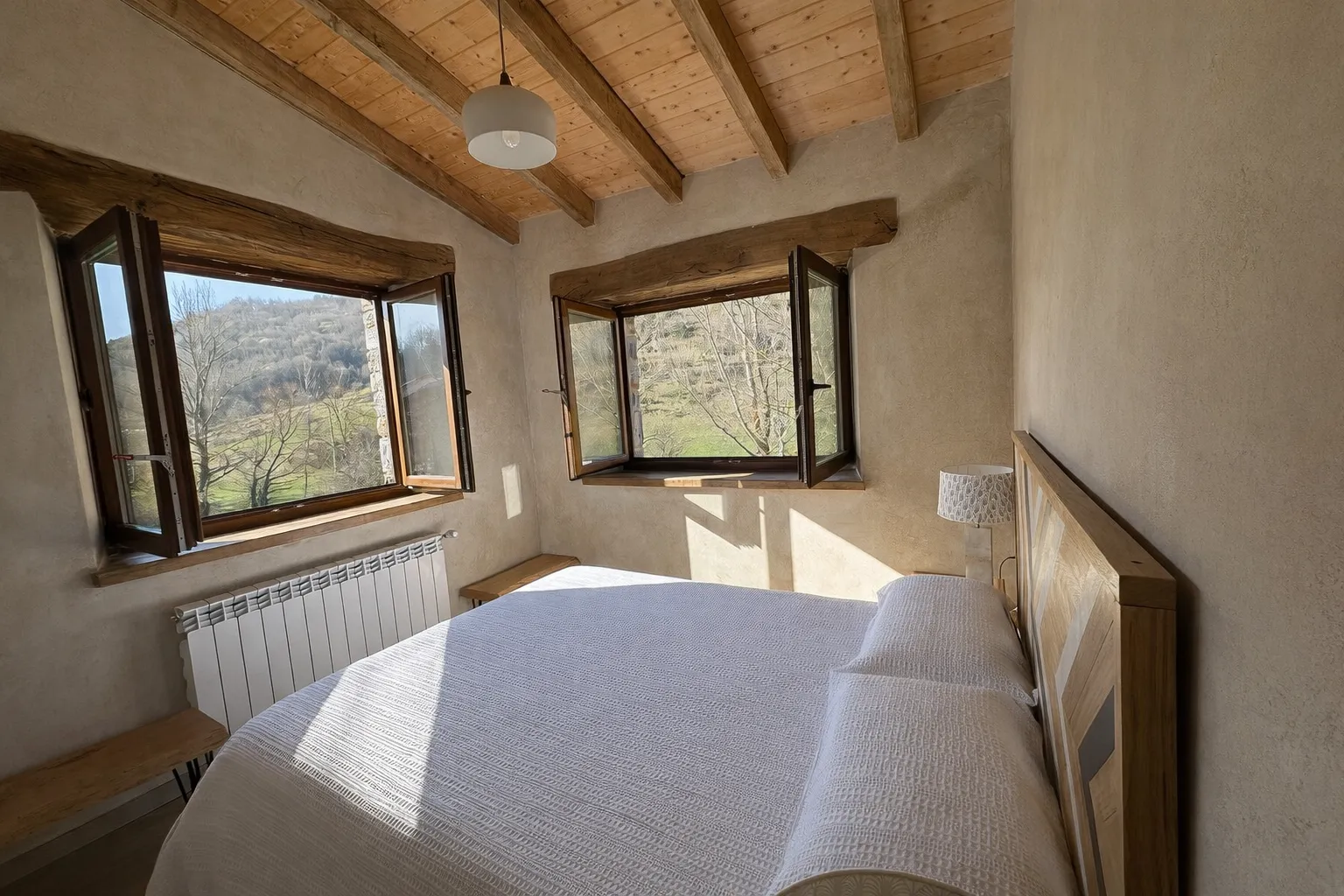 Habitación principal con cama doble y lencería de lujo en casa rural Cumbres de Lores